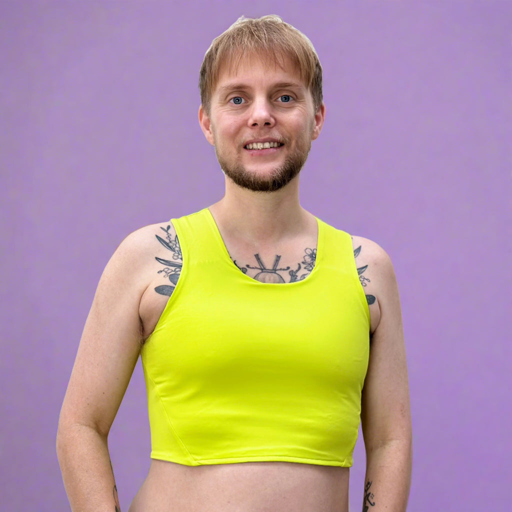 Non-binary person wearing lime green chest binder