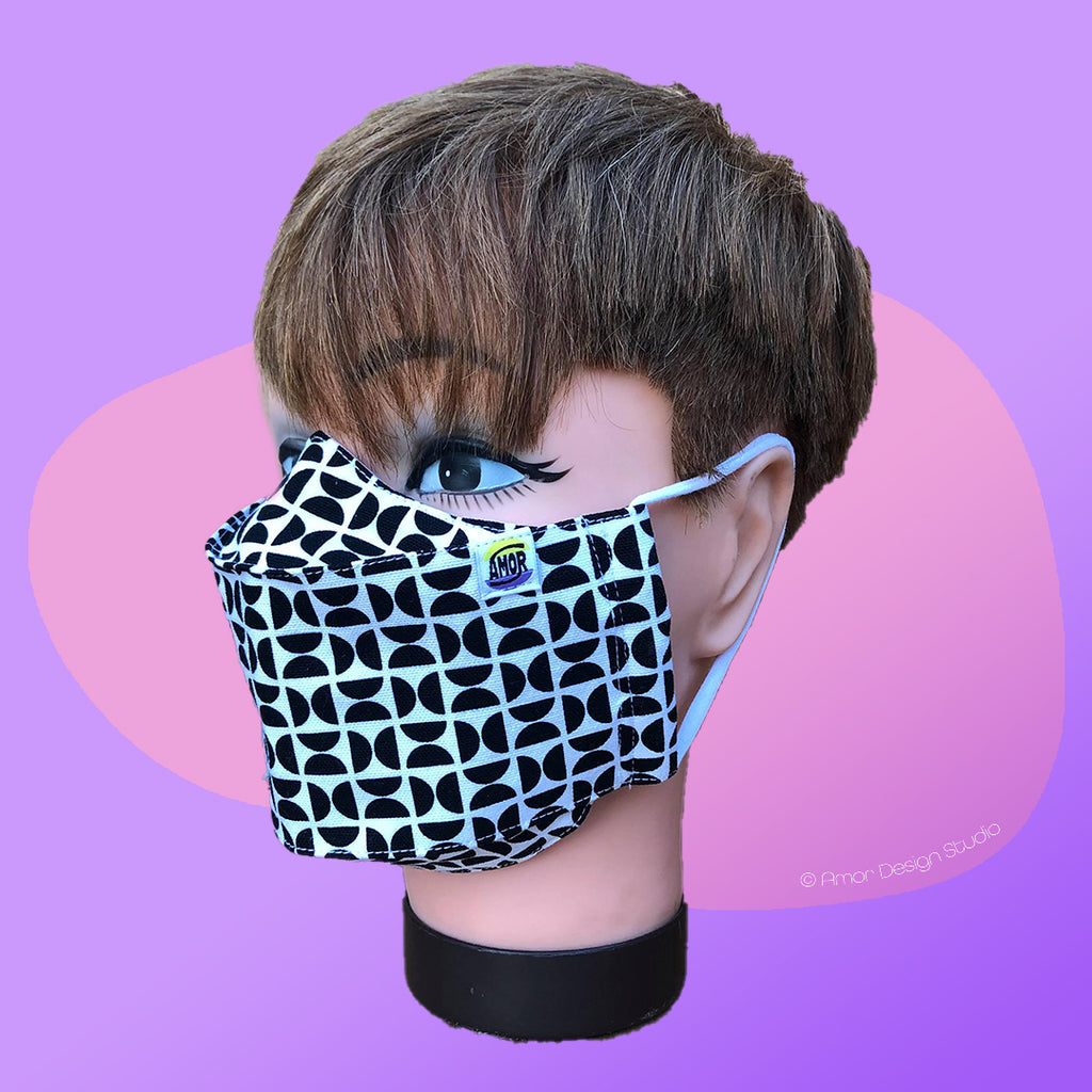 White face mask with black geometric half circles on mode - side