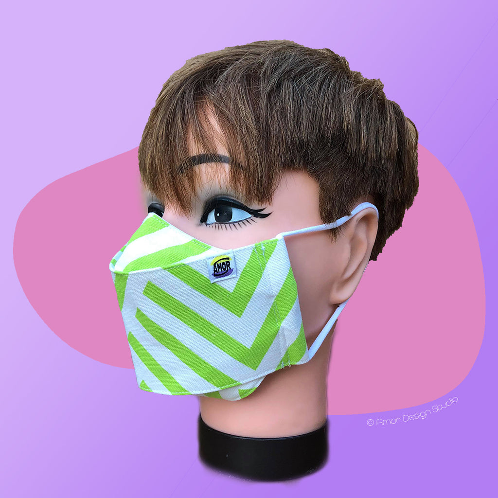 White face mask with green stripes in geometric pattern, on model - side