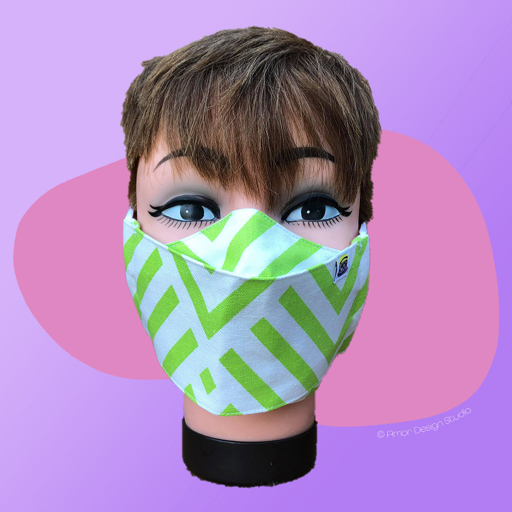 White face mask with green stripes in geometric pattern, on model - front