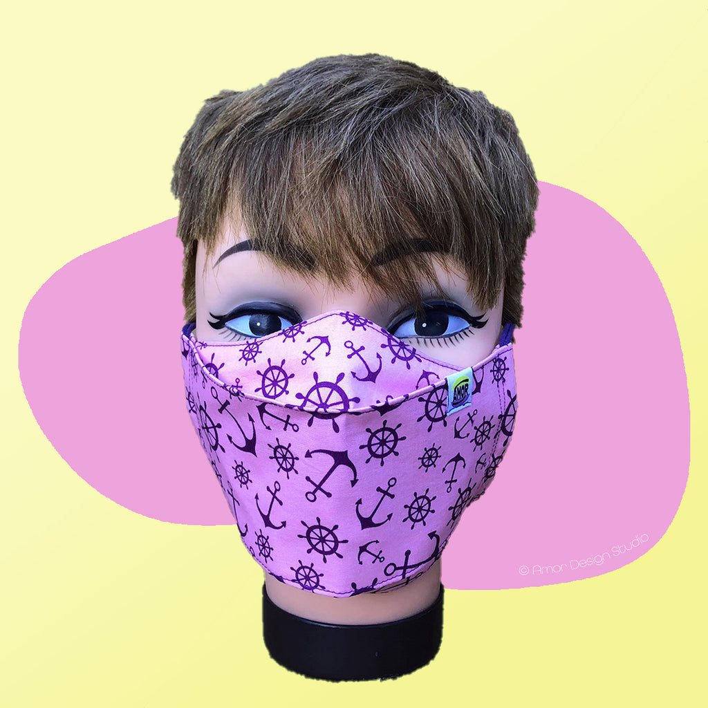 Light pink face mask with dark purple anchors and galvers print, on model - front