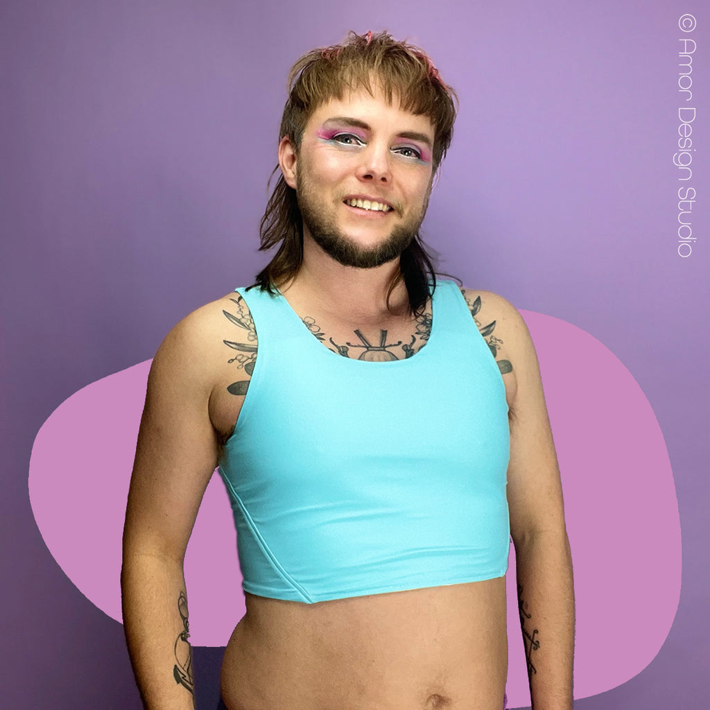 Nonbinary trans person wearing pastel blue reversible chest binder, front.