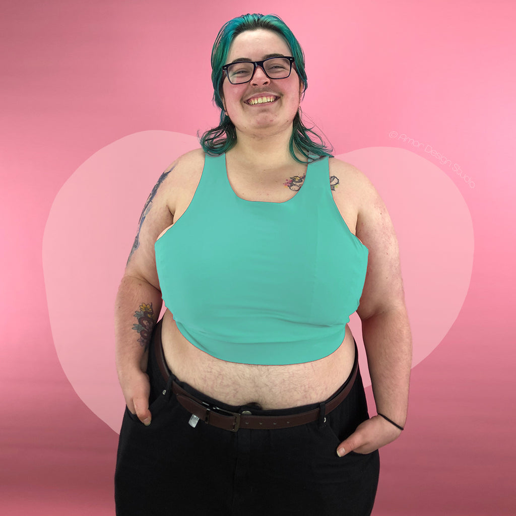 Plus size trans person wearing pastel green mid length, full chest binder - front