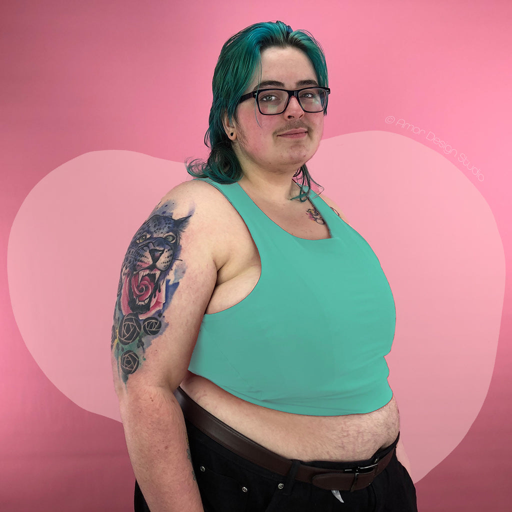 Plus size trans person wearing pastel green mid length, full chest binder - side