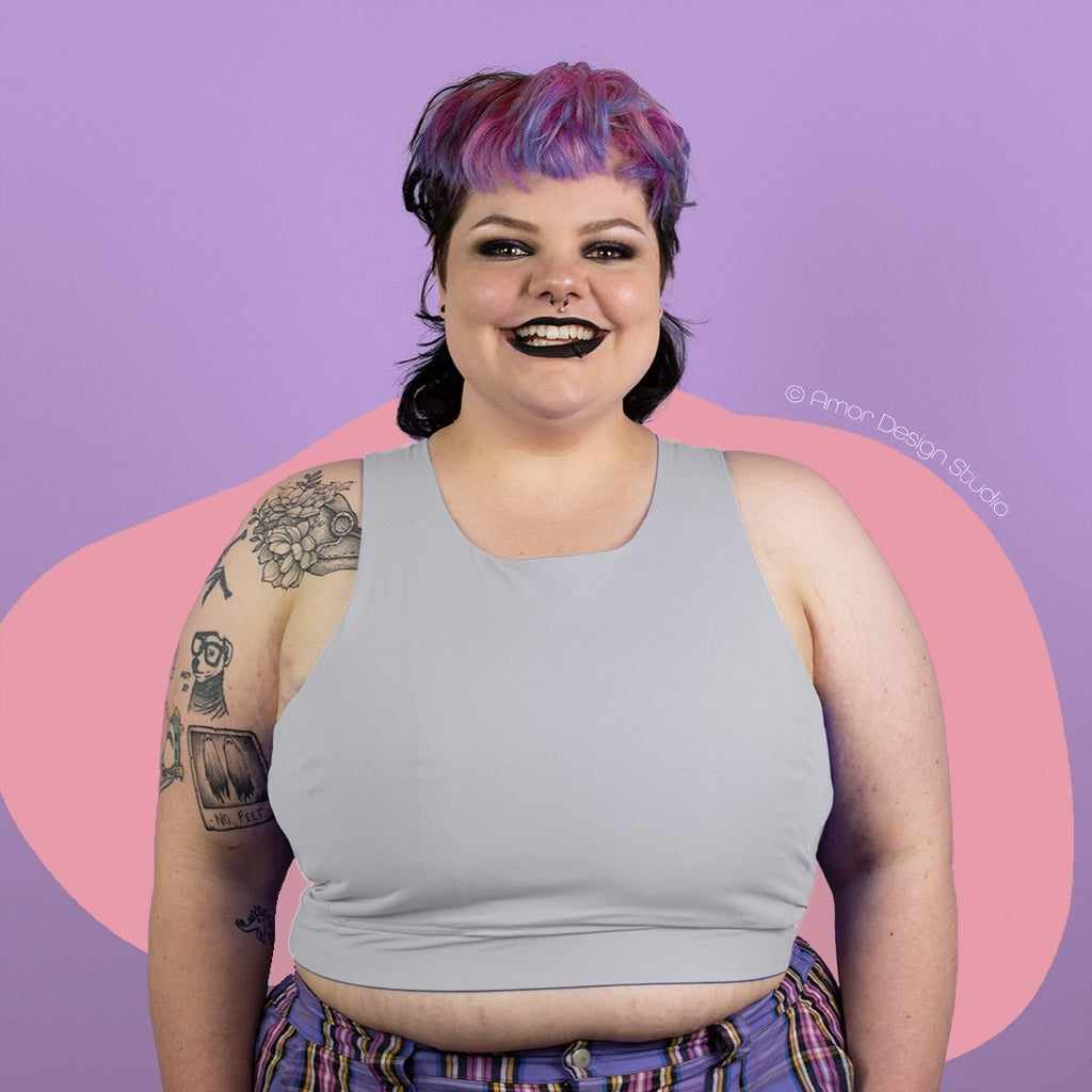 Plus size non-binary person wearing light grey mid length, full chest binder - front