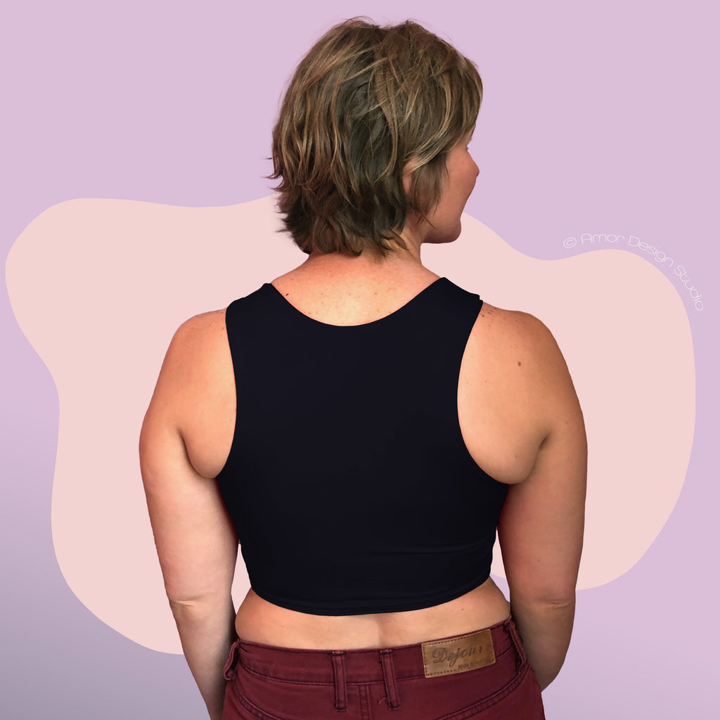 Non-binary person wearing black, mid length, racerback chest binder - back