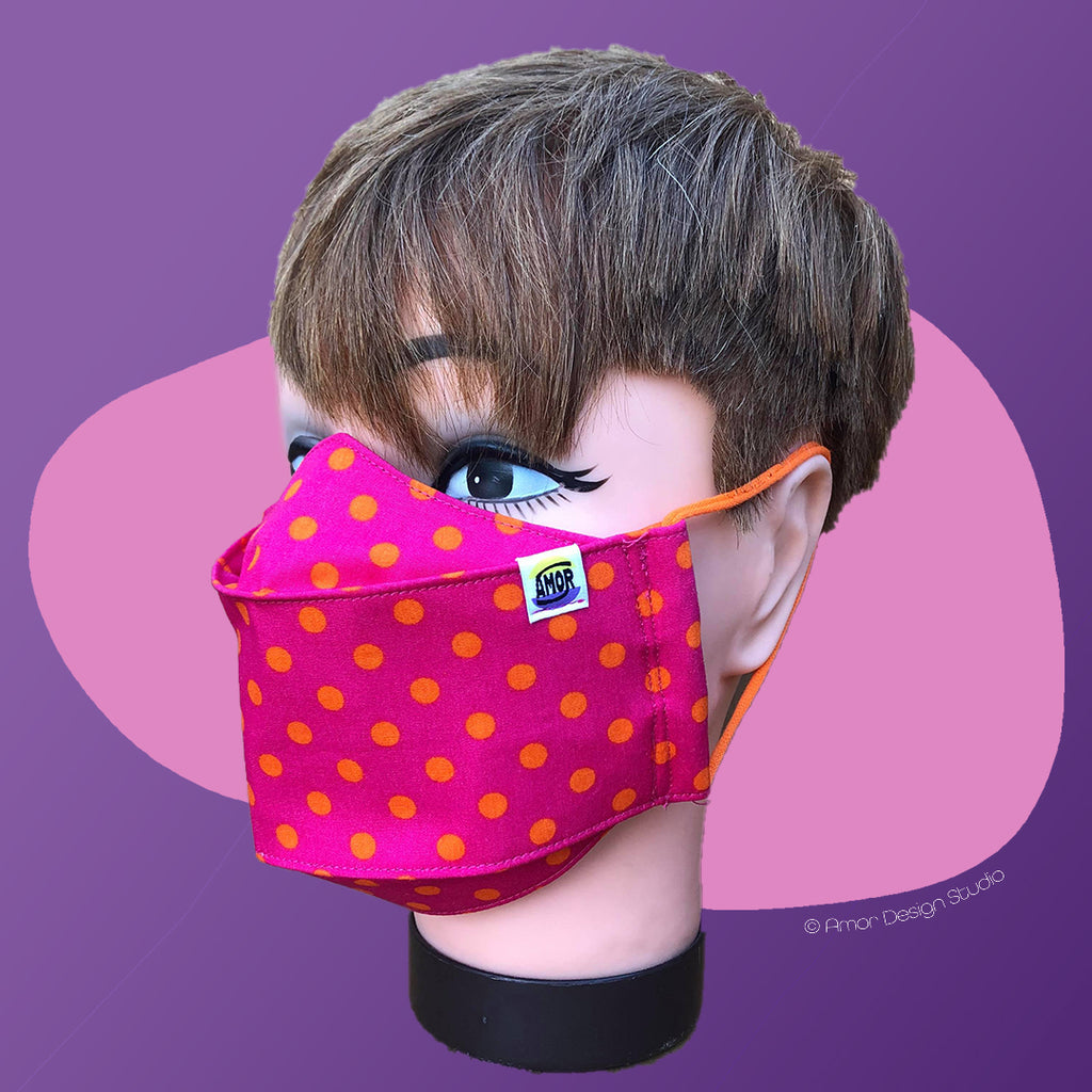 Hot pink face mask with orange polka dots, on model - side
